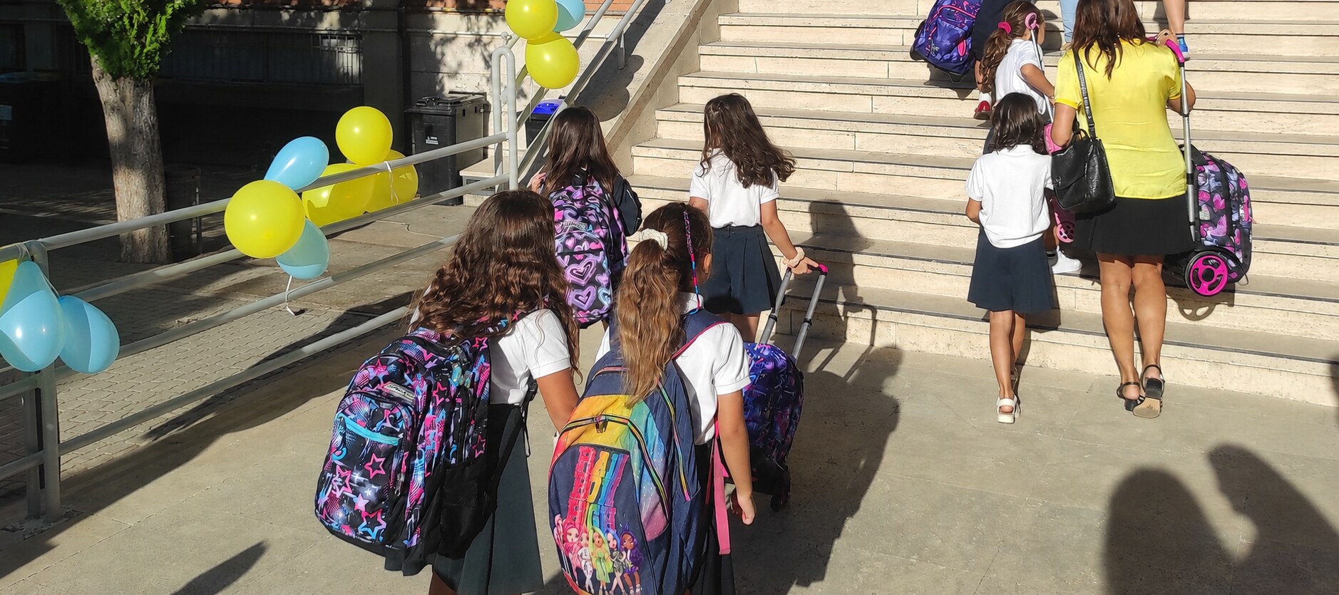 Bambini entrano a scuola il primo giorno tra i palloncini