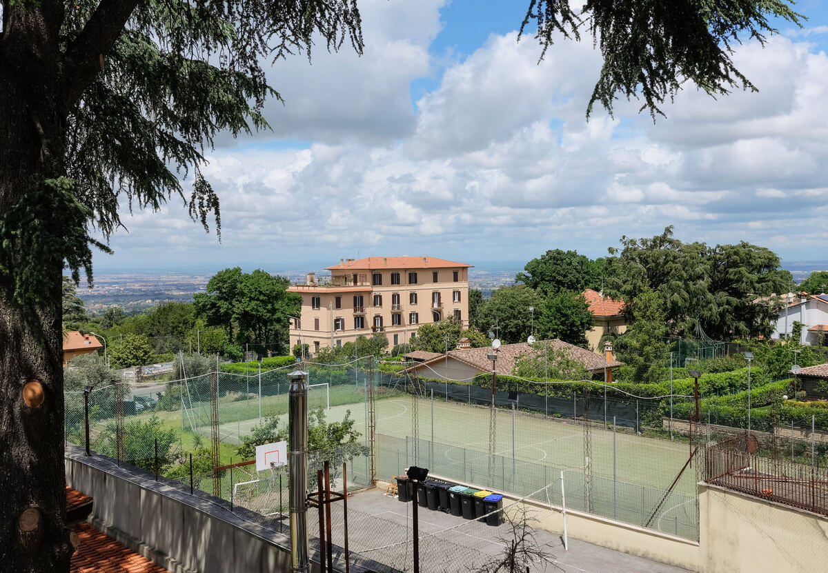 Il campo da calcio della scuola visto dall'alto, con Roma sullo sfondo